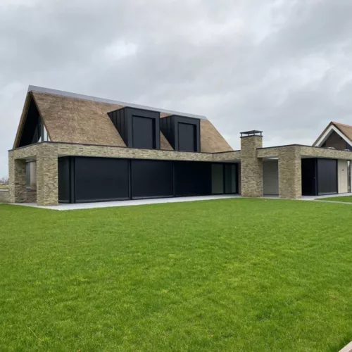Buitenjaloezie raffstore bij woning met rieten dak