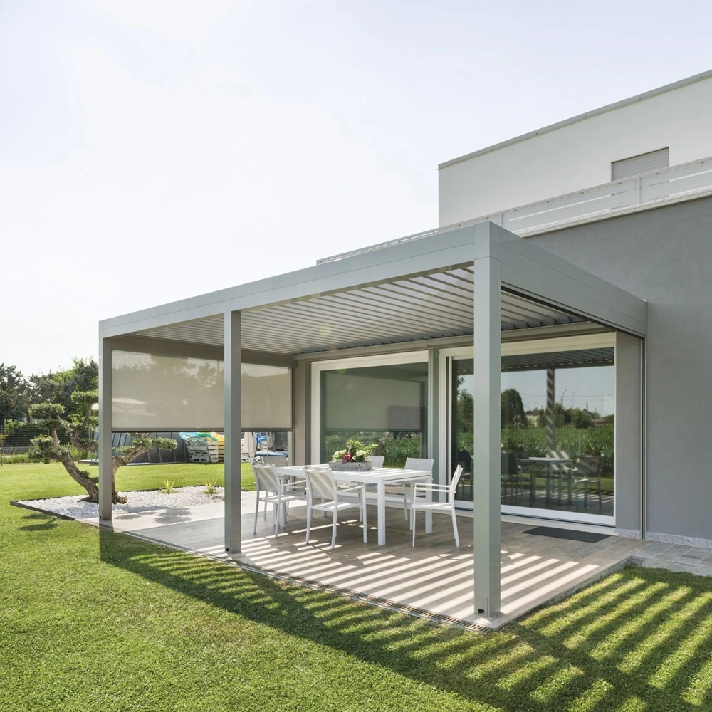 Lamellen overkapping Sway met zonneschermen, witte tuinmeubelen en groene grasmat