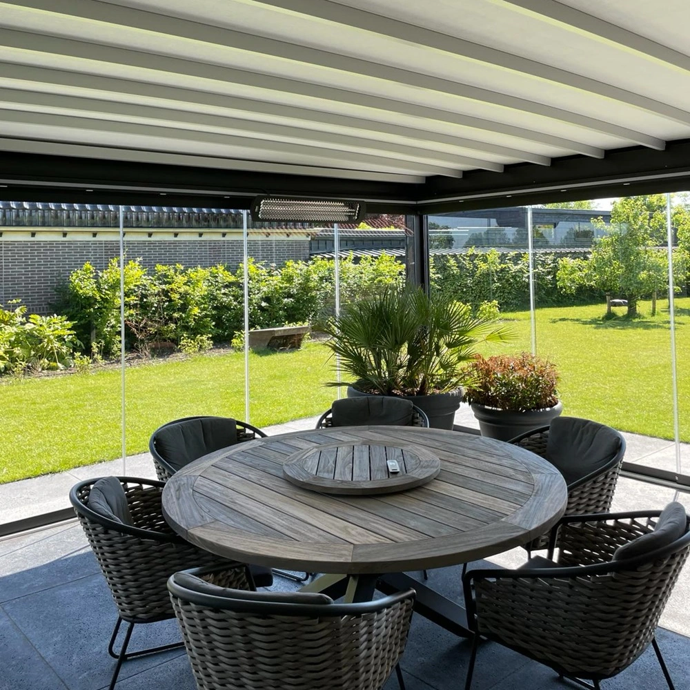 Ronde tuintafel onder Azimut uitvouwbare tuinkamer met glazen schuifwanden