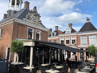 Schaararmscherm boven terras in een historische binnenstad Schaararmscherm boven terras in een historische binnenstad