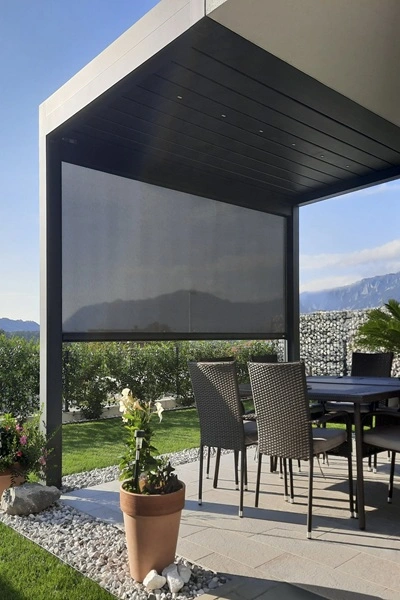 Lamellen overkapping Joy met geïntegreerd scherm en eetset in tuinsetting Lamellen overkapping Joy met geïntegreerd scherm en eetset in tuinsetting