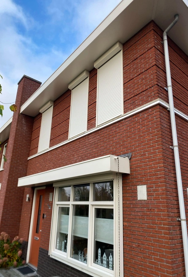 Witte rolluiken op een rode bakstenen woning in Heerenveen