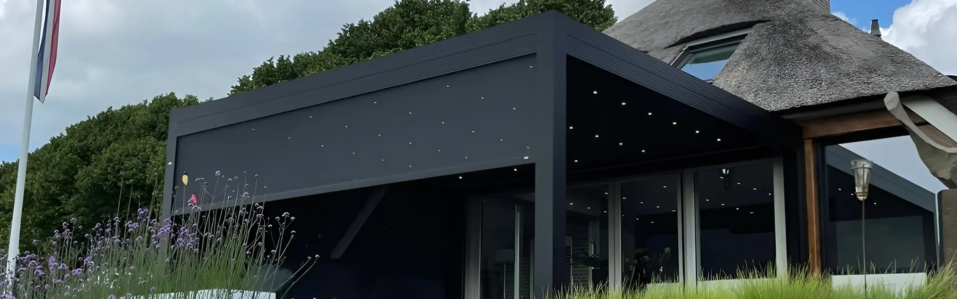 Lamellen overkapping met verlichting bij rietgedekte woning in Wilsum door Veldman Zonwering