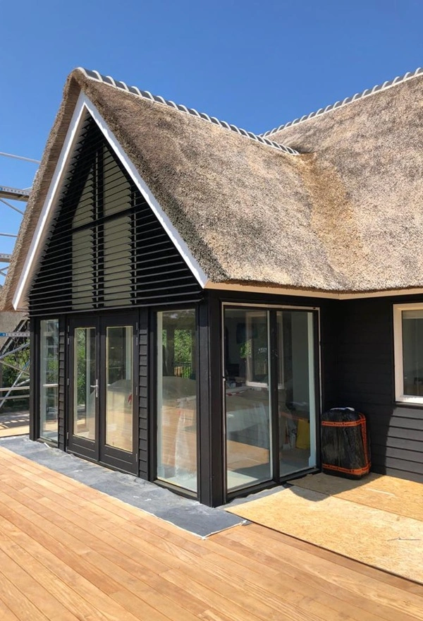 Louvre lamellen op rieten dak woning Ameland, Veldman Zonwering