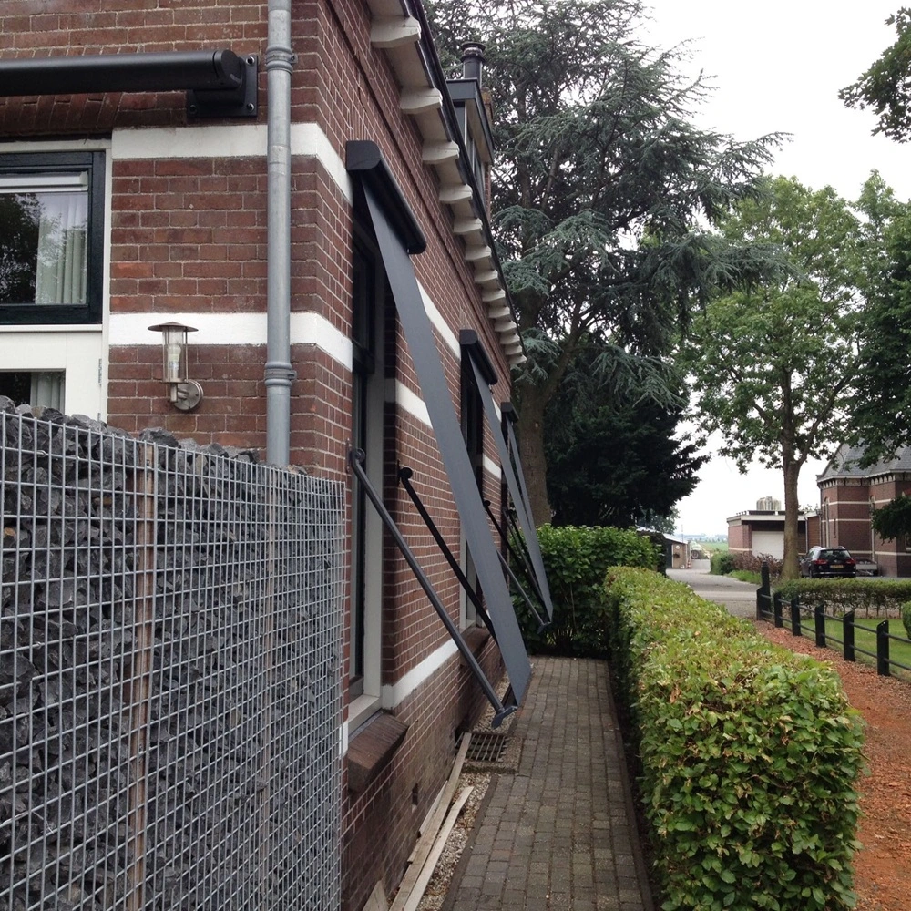 Zijaanzicht van een woning met zwarte uitvalschermen US701