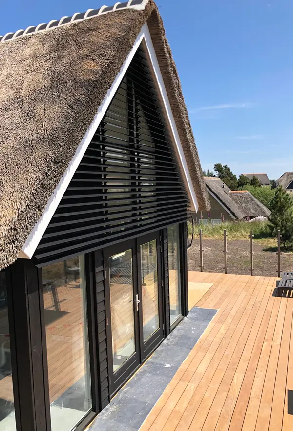 Zwarte louvre lamellen op terras Ameland, Veldman Zonwering