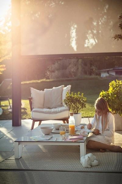Kind ontspant in Gibus tuinkamer met zonwerend screen en ochtendzon Kind ontspant in Gibus tuinkamer met zonwerend screen en ochtendzon